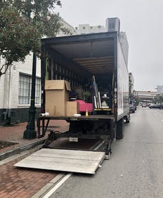 Un camión de mudanzas se carga con muebles y otros artículos.