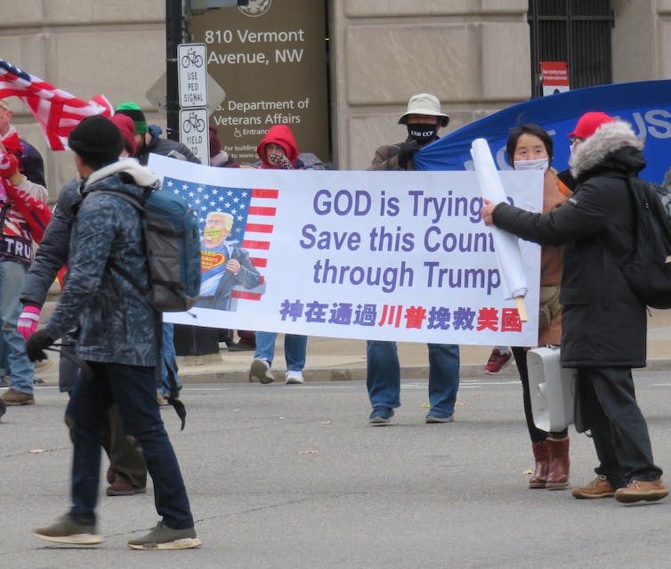 La gente marcha con una pancarta que dice 'Dios está tratando de salvar este país a través de Trump'